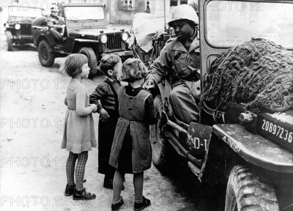 Un G.I. donne du chocolat à des enfants