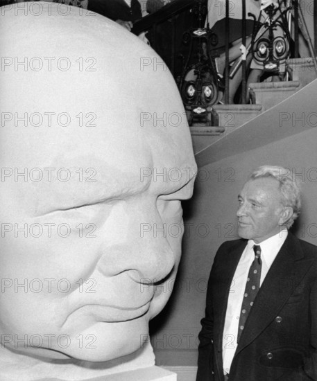 Richard BURTON next to a cement head of Sir Winston Churchill, 1974