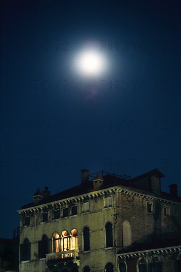 Palace at night with moon above