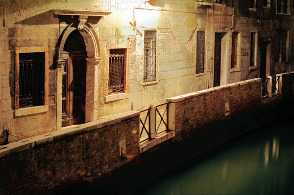 Illuminated alley along the canal, Venice
