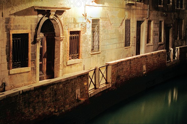 Passage éclairé et bord de canal de nuit