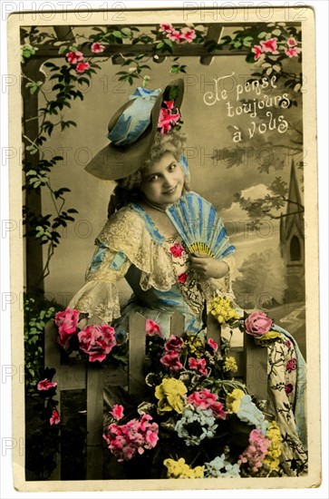 Postcard with a woman among flowers