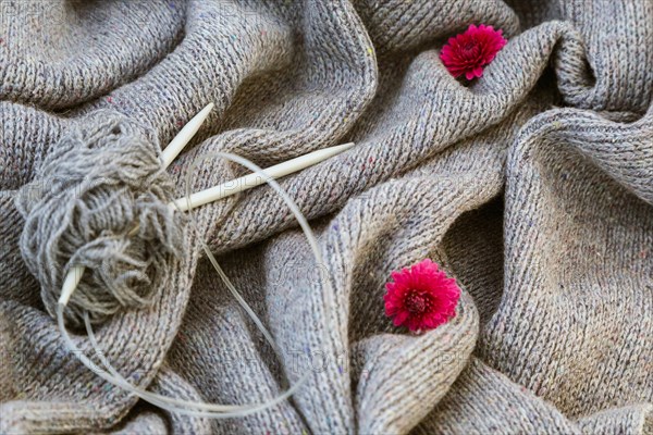 background of knitted gray linen of goat's wool made with knitting needles or on a knitting machine laid in big waves with  metal knitting needles and