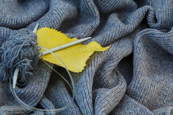 background of knitted gray linen of goat's wool made with knitting needles or on a knitting machine laid in waves with metal knitting needles, yellow