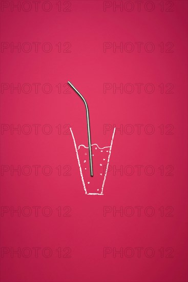 Reusable metal straw in a chalk-drawn glass with beverage on a red background. Eco-friendly drinking straw. Reduce plastic waste concept. Zero waste.