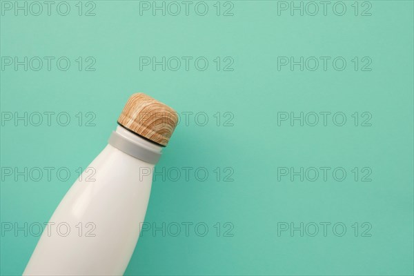 Reusable stylish eco friendly sustainable white water bottle on mint background. Copy space. Flat lay style, top view, close up. Zero waste, sustainab