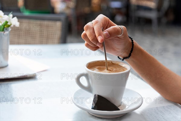 Young woman stirring a coffee. Relaxed concept