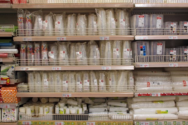 Stack of food plastic disposable glasses and cutlery displayed on a supermarket