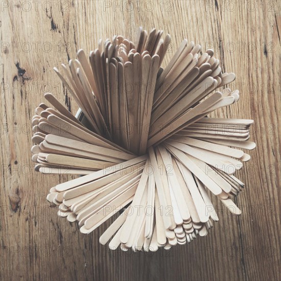 Wooden drink stirrers in a pot on a wooden table
