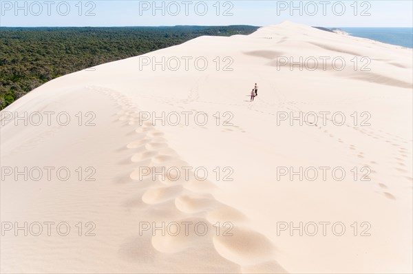 France, Gironde, Bassin d'Arcachon (Arcachon Bay). An adult couple explore the Great Dune of Pyla (Dune de Pilat)