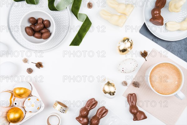 Happy Easter. Stylish stationery background with chocolate eggs. gold and white eggs and accessories on white background. Table decorating for holiday