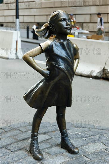 Girl in front of Charging bull sculpture at New York, USA,