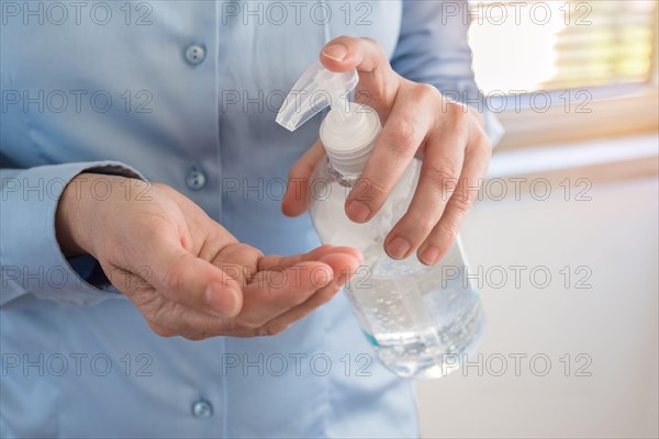 Woman cleaning her hands with alcohol based sanitizer gel to prevent the spreading of coronavirus. Hygiene and Covid-19 concept.