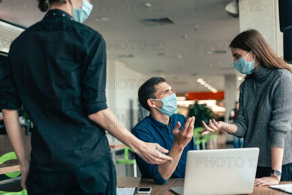 business team in protective masks discussing work issues.