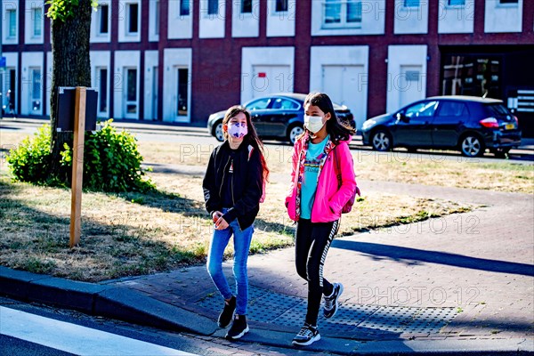 Children walk to school while wearing face masks as a precaution against the spread of coronavirus.School children will go back to primary school full-time beginning 8th June and will have to adapt to the coronavirus crisis.