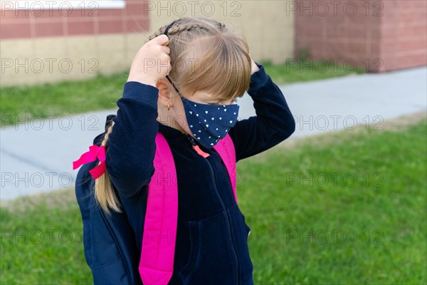 Young student caucasian girl wearing protective cotton mask for school. Return back to school, reopening, new life.