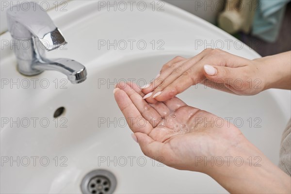 Personal hygiene concept. Woman washing hands with soap. Coronavirus or COVID-19 prevention. Hand washing process