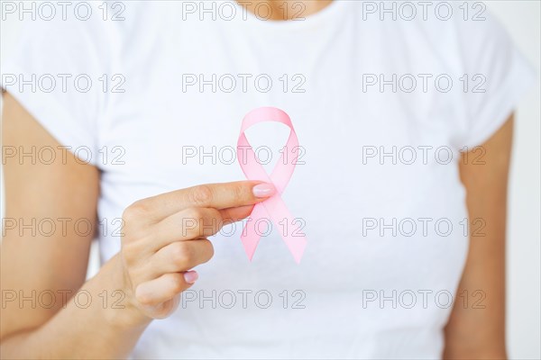 Woman using pink ribbon to support breast cancer cause or AIDS