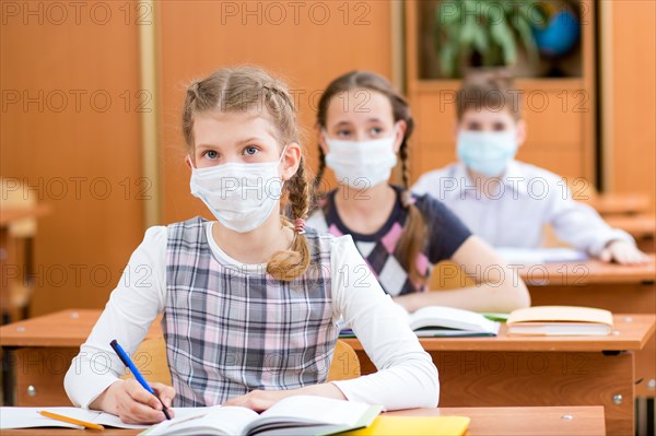 schoolkids with protection mask against flu virus at lesson