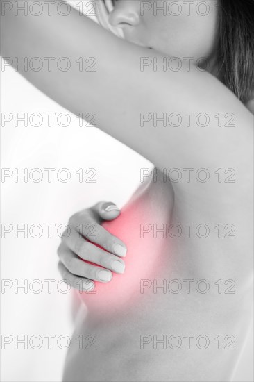 woman checking breast for signs of cancer