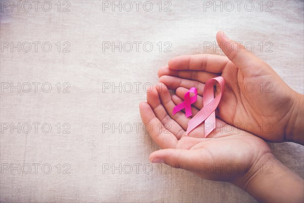 Hands holding Pink Ribbons toning background, Breast cancer awareness and Abdominal cancer awareness