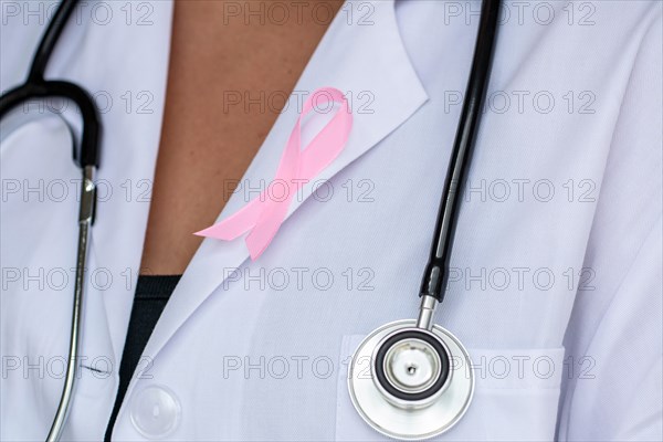 close-up of Doctor with ribbon formed breast cancer awareness symbol
