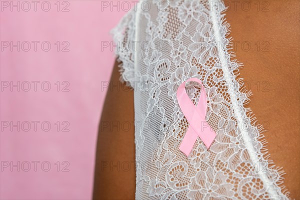 young african american woman with pink ribbon  isolated on pink , breast cancer concept