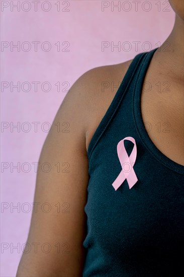 young african american woman with pink ribbon  isolated on pink , breast cancer concept