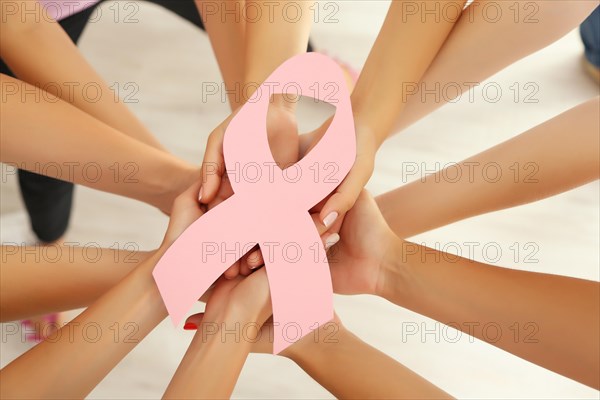 Women hands joined in circle holding breast cancer symbol