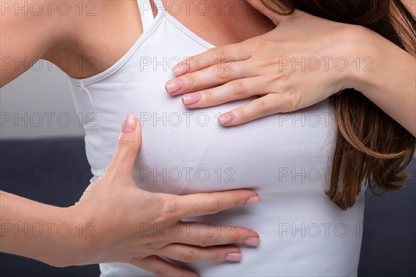 Close-up Of A Woman's Hand On Breast Showing Cancer Symptom