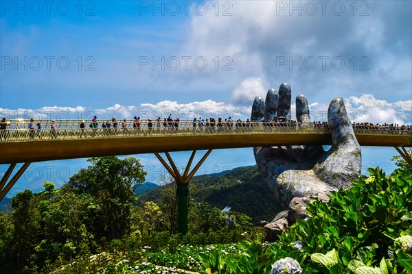 Danang, Vietnam - April 6, 2019: The Golden Bridge is lifted by two giant hands in the tourist resort on Ba Na Hill in Danang, Vietnam. Ba Na Hill mou