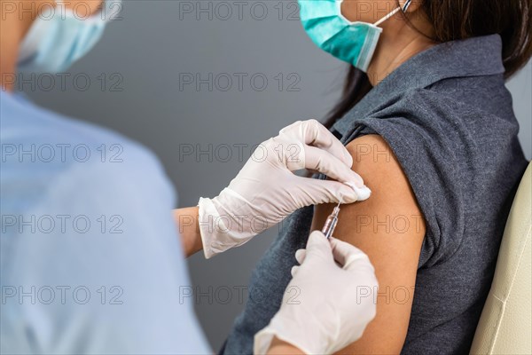 close up doctor holding syringe and using cotton before make injection to patient in medical mask. Covid-19 or coronavirus vaccine