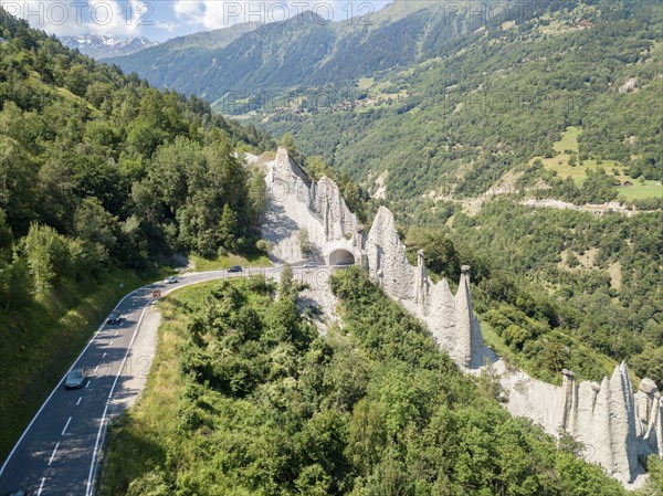 Euseigne, Switezrland - July 14, 2019: Aerial view of Pyramides d'Euseigne in Swiss Alp. Rocks stay balanced on eroded former glacier moraine. A road