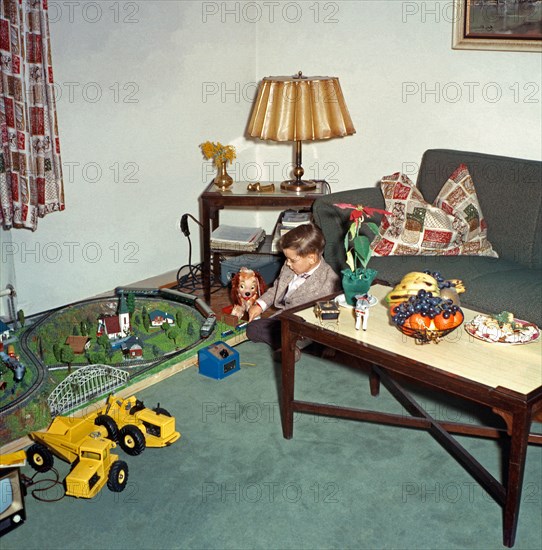 Boy playing with his new train set at Christmas, c. 1960
