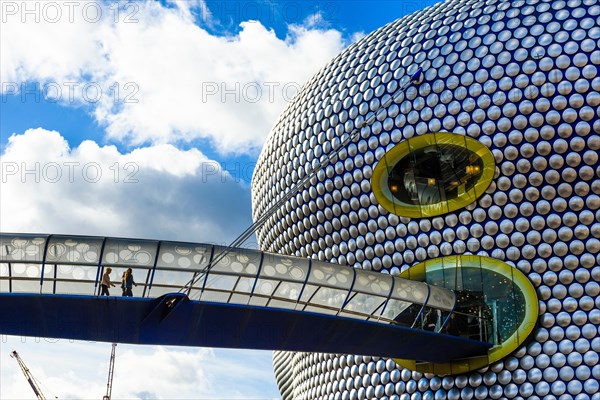 Pedestrians on footbridge linking to the iconic Selfridges store in Birmingham England UK