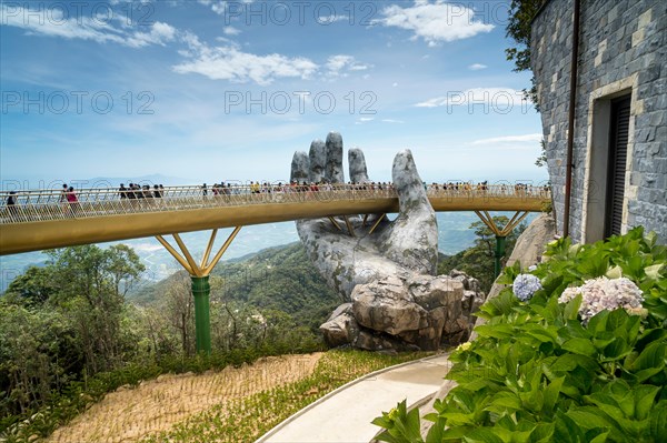 The panoramic view of Golden Bridge is lifted by two giant hands in the tourist resort on Ba Na Hill in Danang, Vietnam.