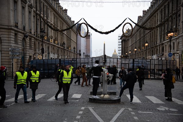 Paris, France, 8th December, 2018. Protesters wearing yellow vests near a police roadblock barring access to place de la Concorde, rue Royale, Paris. About 10,000 protesters wearing yellow vests demonstrated in Paris for the fourth weekend in a row to protest against taxes on fuel and decrease in purchasing power. Security was reinforced as previous week protests turned violent. Credit: Christelle Chanut/Alamy Live News