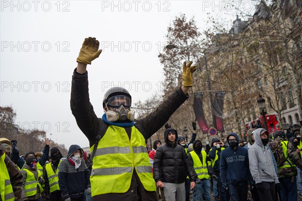 Champs-Elysees, Paris, France. 15th Dec 2018. Protestor wearing gas mask raises his hands to police. Yellow Vests (Gilets Jaunes) protests, Champs-Elysees, Paris, France, December 15, 2018. Credit: Julien Garnier/Alamy Live News