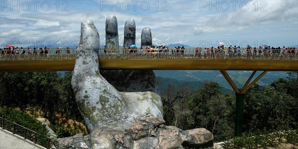 Da Nang, Vietnam - August 18, 2018: Tourists in the Golden Bridge. The Golden Bridge is a 150 m long pedestrian bridge in the Ba Na Hills in Da Nang.