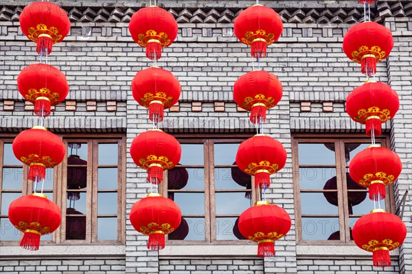 Group of red lanterns hanging on the black brick wall in the Chinese new year, Three lanes and seven alleys, Fuzhou,China. 
The building made of  blac