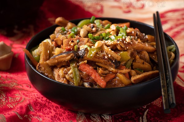 Traditional Chinese Buddha's Delight stir fry for New Year  served in black bowl on traditional red fabric cover