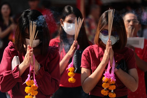 Women pray while wearing dust masks during the celebration at Leng Noei Yi Temple in Chinatown, Bangkok.The Lunar New Year, also known as Spring Festival in China marks the beginning of the Year of the Rat. The ethnic Chinese-Thai family pray for good fortune and wear masks for dust protection as the country struggles to contain worsening air pollution.