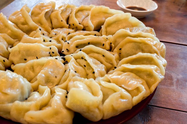 Hand-made Chinese dumplings Jiaozi with black sesame seeds beautifully arranged in a circle for Chinese New Year
