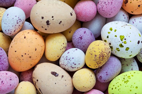 Still life photo of lots of colourful speckled candy covered chocolate easter eggs