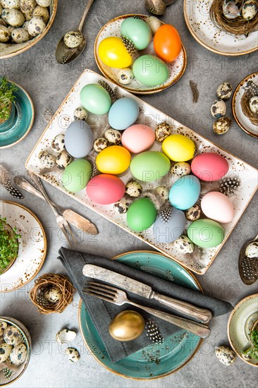 Easter dinner table decoration with colored eggs. Top view. Vibrant colors