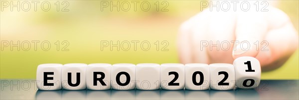 Hand turns dice and changes the expression "Euro 2020" to "Euro 2021".