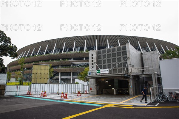 Tokyo, Japan. 21st July, 2020. A man walks outside of a subway station at the Japan National Stadium in Shinjuku City which will be use for the Olympic Games Tokyo 2021.Due to the Covid-19 outbreak, the Olympic Games Tokyo 2020 were postponed for the first time in history. The Opening Ceremony of the Olympic Games Tokyo 2020 will now be held on 23rd July 2021 instead of 24 July 2020. Credit: SOPA Images Limited/Alamy Live News