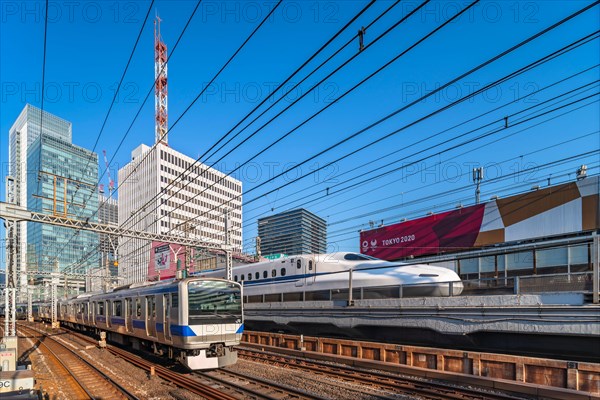 tokyo, japan - february 16 2021: Tokyo Sports Square building promoting Tokyo 2020 Olympic Games along the tracks of Yurakucho station with a E531 ser