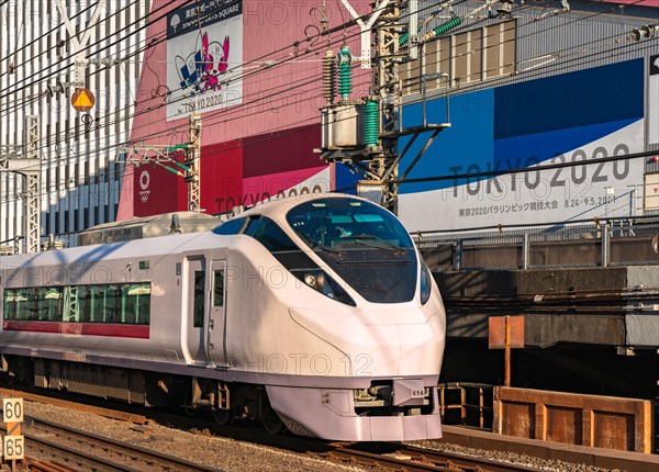 tokyo, japan - february 23 2021: Close up on a E657 series limited express train passing in front of the Tokyo Sports Square building promoting the To