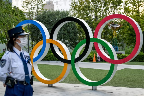 Tokyo, Japan. 09 May, 2021. A Policewoman seen near the Olympic Rings during a protest against the Tokyo Olympics in front of the New National Stadium, the main stadium for the Tokyo Olympics. Credit: ASWphoto/Alamy Live News